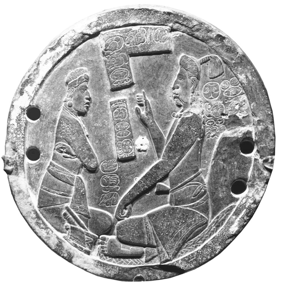 Figura 6. Espejo de pirita proveniente de Xultún con la inscripción <strong>yo chi</strong>-<strong>ni AJAW</strong>, <em>yochin ajaw</em>,<em> </em>“Señor del sumidero”, en la parte inferior (Matteo y Krempel, 2011: 960).